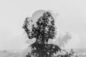 Silhouette of Asian woman behind tree branch near endless ocean