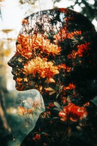 A double exposure of a woman's face with flowers in her hair